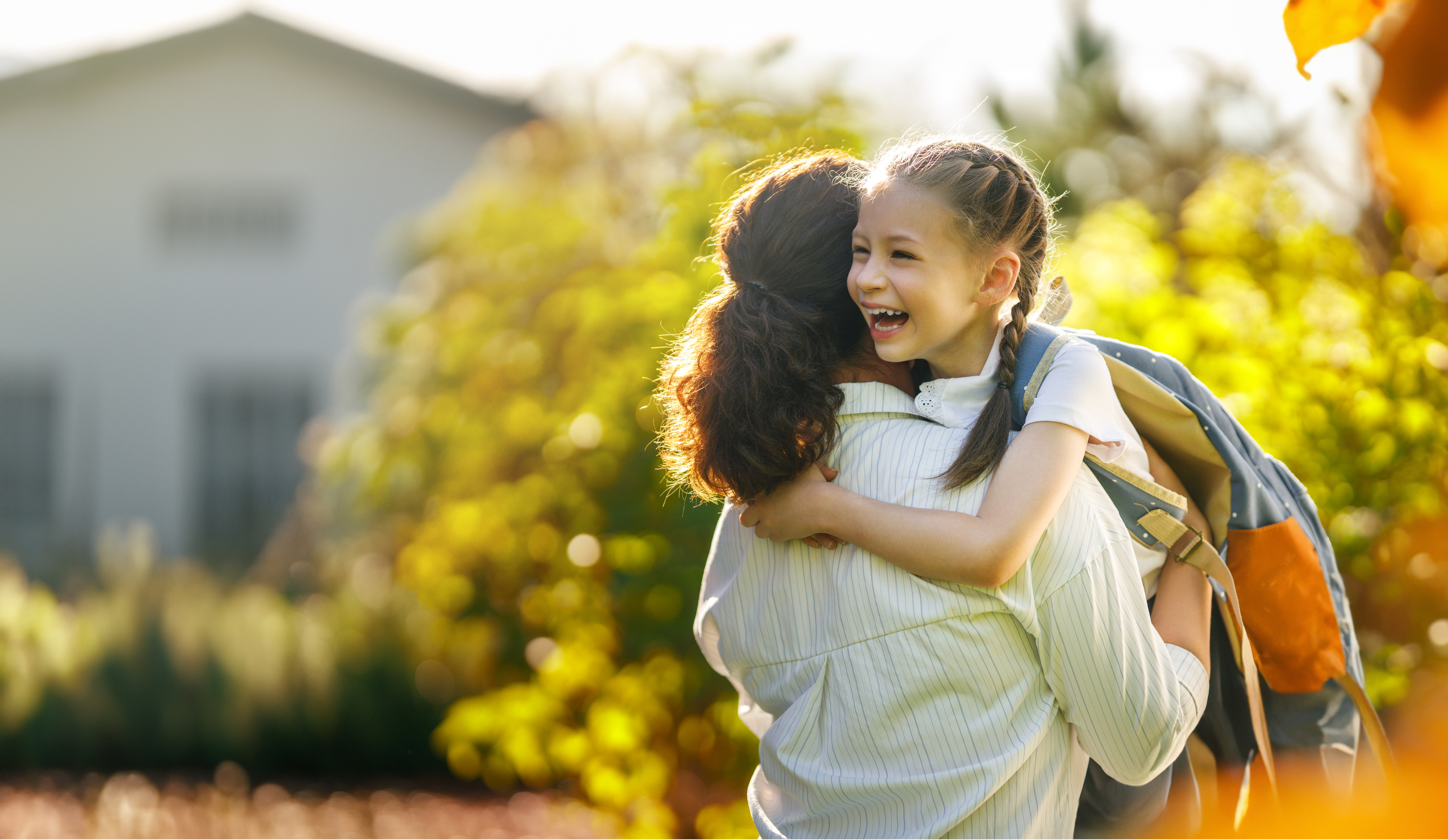 Mother hugs daughter as she goes to school